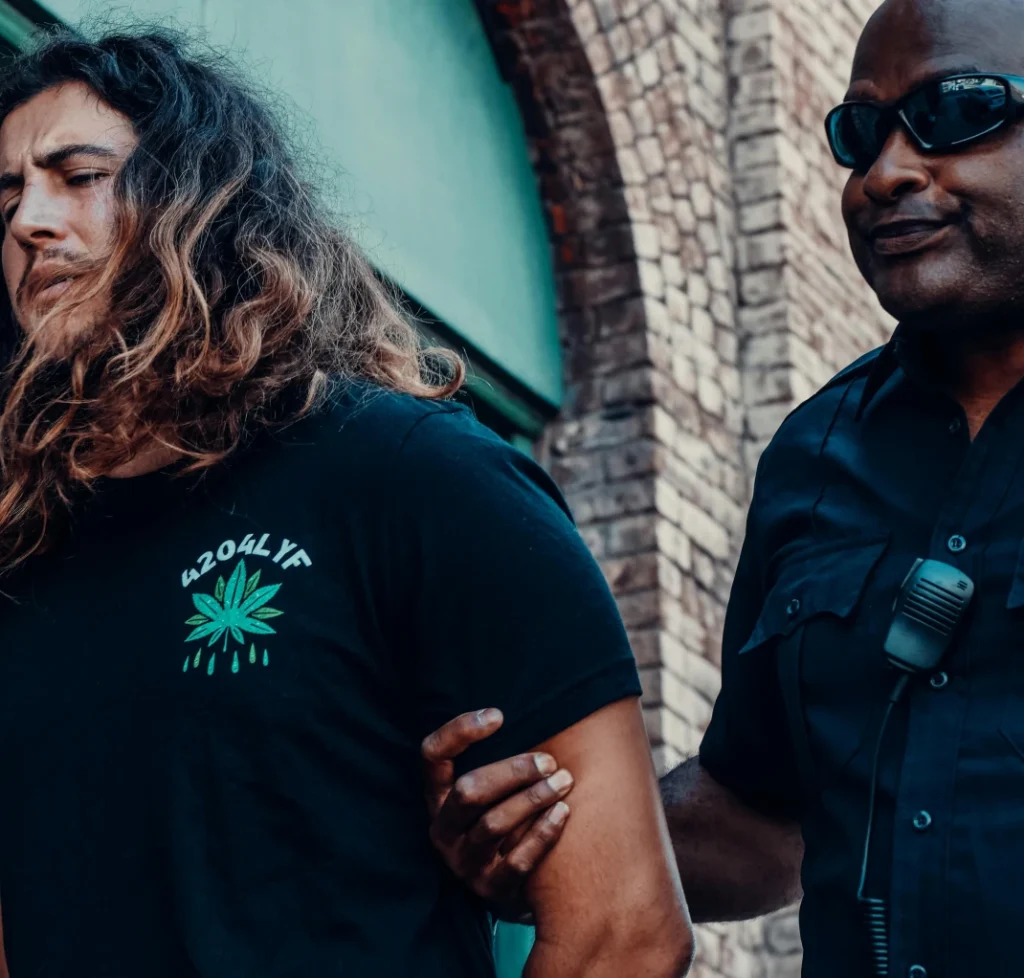 Police officer detaining a man by the arm, representing an assault on a public servant charge