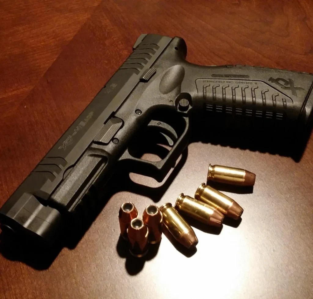 Handgun and bullets on a table, representing an unlawful carrying of a weapon charge